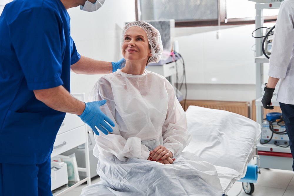 a doctor talks to a smiling patient before a procedure